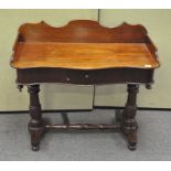 A Victorian mahogany desk, of serpentine form, with a front drawer and carved back,