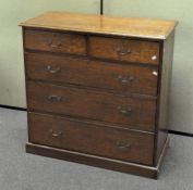 An oak chest of drawers, comprising two short and three long drawers,