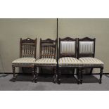 A pair of mahogany dining chairs with carved and spindle backs and supported on turned legs,