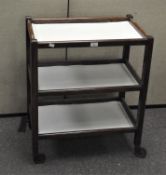 A 20th century three tiered tea trolley, raised on wheels,