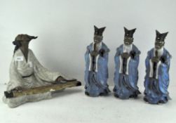 A collection of Chinese figures, three standing and dressed in blue robes,