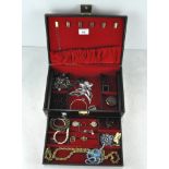 A vintage jewellery box containing a quantity of costume jewellery,