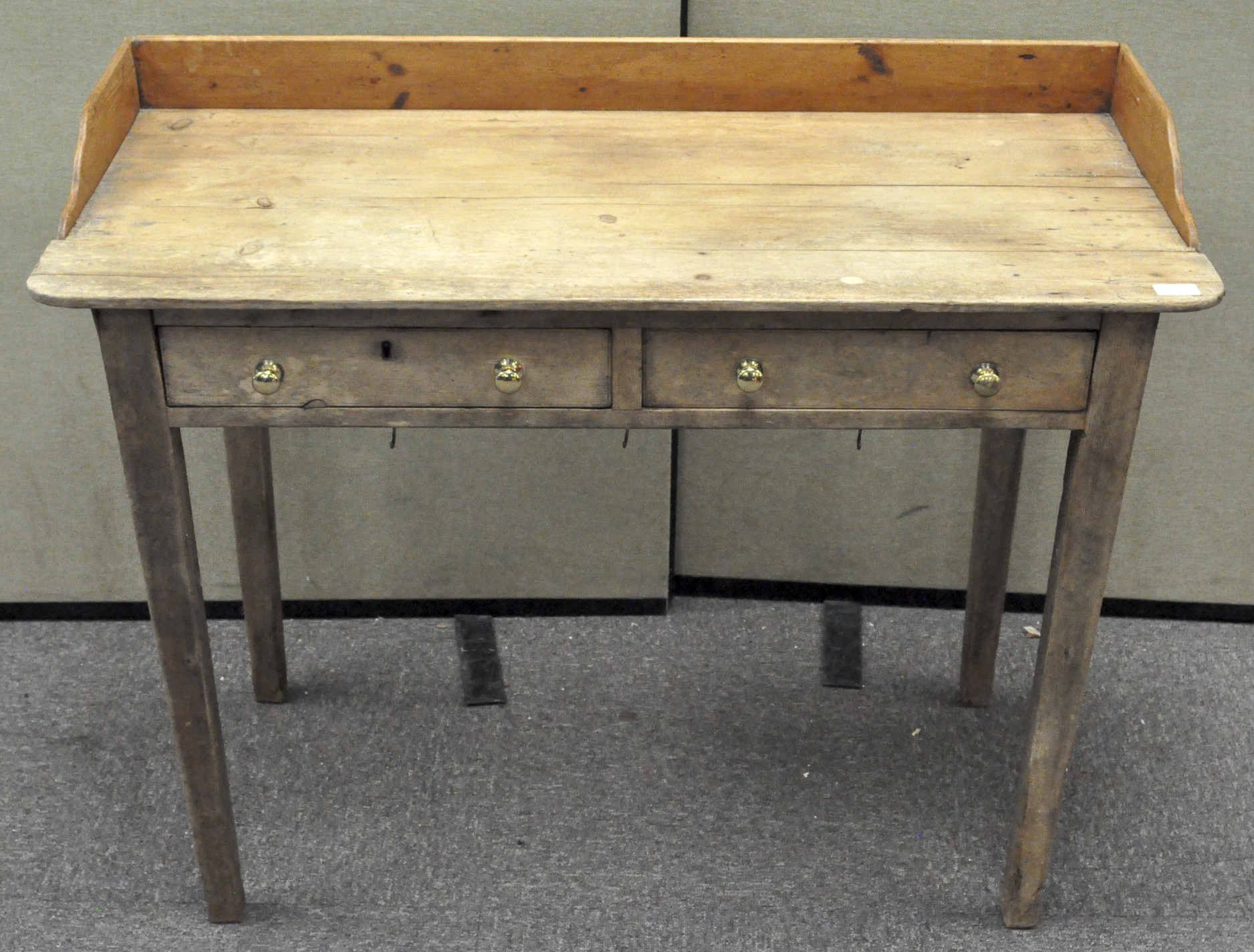 An early 20th century pine desk with two drawers to the front,