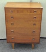 A retro teak chest of drawers, comprising five long drawers,