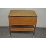 A vintage drop leaf trolley table, raised upon original castors,