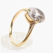 A yellow metal ring set with an oval cut 11mm x 7.5mm colourless quartz.