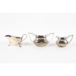 A late Victorian silver half fluted cream jug and sugar bowl,