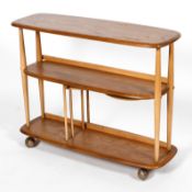 An Ercol beech and elm divider bookcase, two tiers, on rollers,