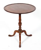 A George III mahogany tilt top tripod table, with reeded baluster stem issuing tripod legs,