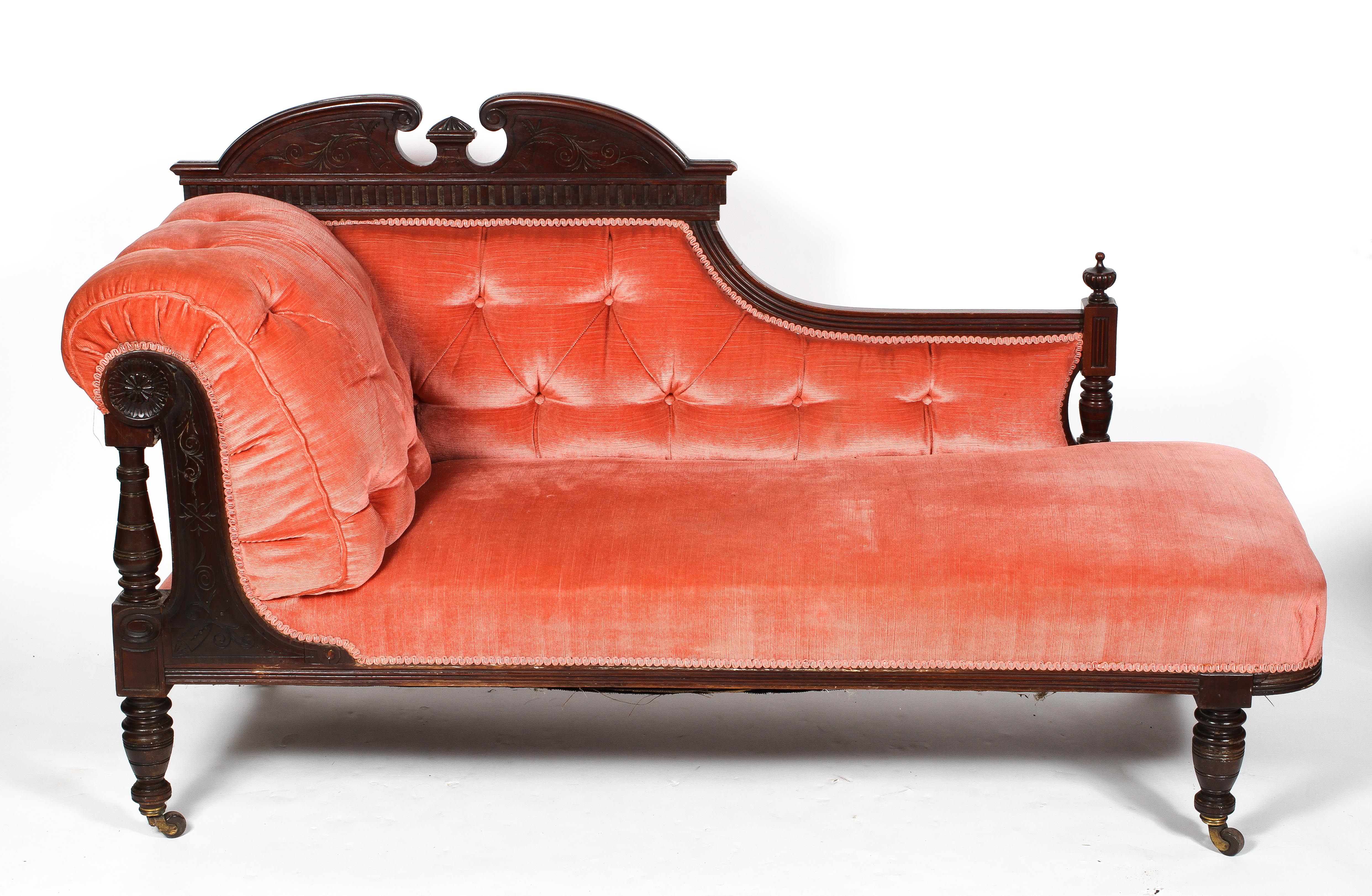 A Victorian walnut framed chaise longue, with pink upholstery,