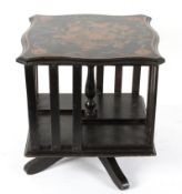 A late Victorian ebonised tabletop revolving bookcase, inlaid with birds and foliage,