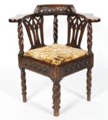 A Victorian oak corner chair, with barley twist supports and legs, carved with bands of flowerheads,