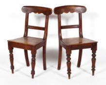 A pair of Victorian mahogany dining chairs, with a bar back, solid seat and turned legs,