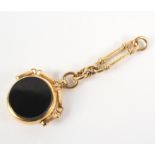 A yellow metal bloodstone and onyx swivel fob with partial chain attachment.