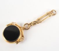 A yellow metal bloodstone and onyx swivel fob with partial chain attachment.