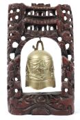 A Chinese brass bell and stand, the hardwood stand carved with dragons,