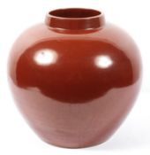 A large red glazed ceramic vase of globular form,