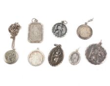 A collection of eight St Christopher pendants, one with a chain. Gross weight: 27.7 grams