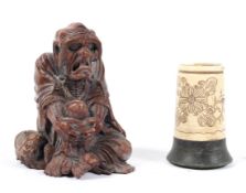 A Chinese carved wood figure of an old man seated holding his knees, a dragon beside him,