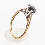 A yellow and white metal ring set with a round faceted cut black diamond estimated to weigh 1.14cts.