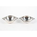 A pair of continental silver porringers, of hammered form, twin handled,