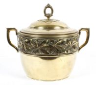 A brass two handled bowl and cover, possibly WMF, embossed with berries and flowers to the rim,
