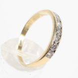 A yellow metal half hoop ring set with seven round brilliant cut diamonds