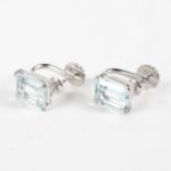 A white metal pair of clip on earrings.