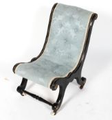 A Victorian ebonised nursing chair, scroll-shaped with gilt metal foliate mounts,
