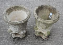 A pair of cast stone garden urns, with foliate decoration, in monopodia,