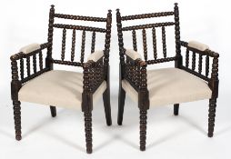 A pair of bobbin turned armchairs, late 19th century, each ebonised and upholstered in cream linen,