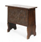 An 18th century six plank oak coffer, the front carved with scrolls and fan shaped ornament,