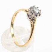 A yellow and white metal ring set with a round brilliant cut diamond