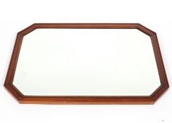 A large mahogany effect wall mirror, of canted rectangular form,