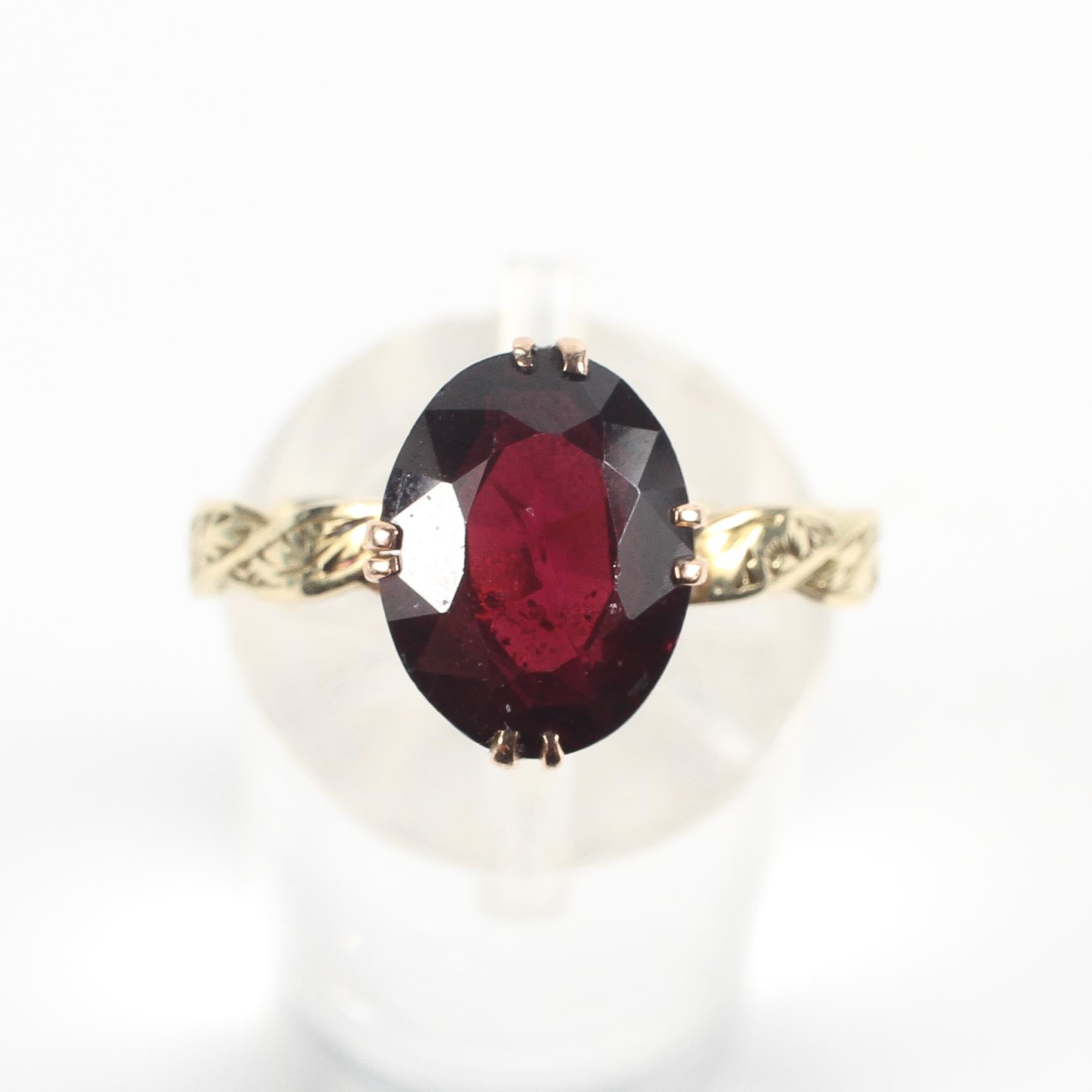 A yellow metal ring set with an oval faceted cut rhodolite garnet measuring approximately 9. - Image 2 of 3