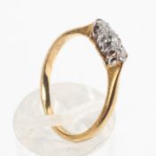 A yellow and white metal ring set with three old brilliant cut diamonds