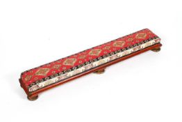 A long upholstered foot stool, with red painted frame and gilt compressed bun feet, 20th century,