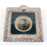 A small late Victorian silver photo frame, of square form with highly embossed borders,