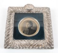 A small late Victorian silver photo frame, of square form with highly embossed borders,