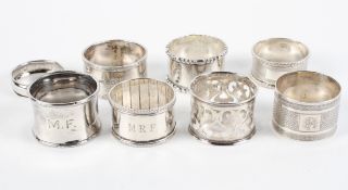 A collection of eight silver napkin rings, including two with engine turned decoration,