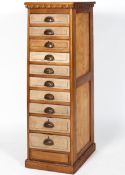 An oak ten drawer cabinet, with egg and dart moulding and fielded panel drawers,