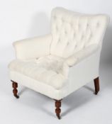A Victorian button back armchair, with scrolled arms, on turned front legs and casters,