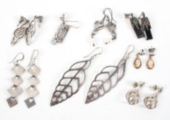 A collection of eight pairs of silver earrings of variable designs. Gross weight: 34.4 grams