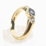 A yellow metal ring principally set with an oval cut 5mm x 4mm pale blue sapphire