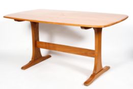 An Ercol dining table, in light elm, of rounded rectangular form on a trestle type base,