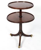 A Georgian two tier dumb waiter, the graduated circular tiers with raised edges on a tripod base,