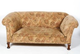 A Chesterfield sofa, with drop arm, on turned legs,
