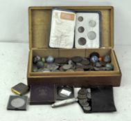 A wooden box containing assorted collectables, including GB coins, marbles,