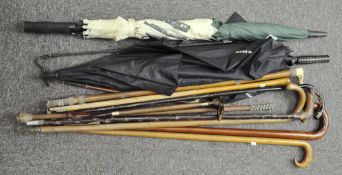 A selection of vintage umbrellas, sticks and horse crops,
