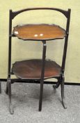 A Victorian mahogany folding cake table, two tiered on splayed feet,